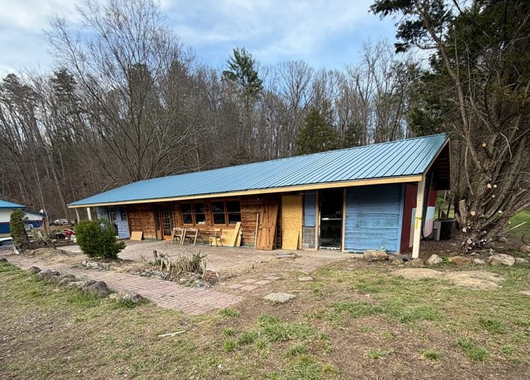 Renovations on an old building with blue painted wood walls and metal roof