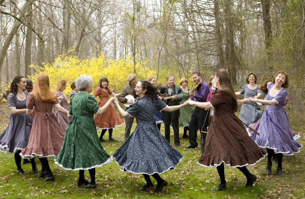 Members of the FiddleKicks dance in a circle while other members play the banjo, guitar, fiddle and cello. Photo courtesy of the FiddleKicks