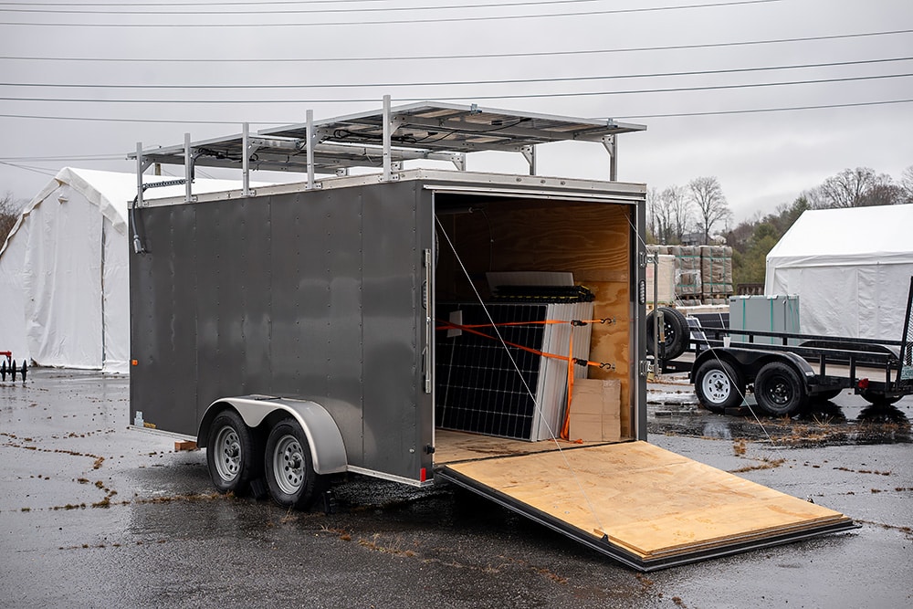 solar microgrid trailer sits in a rainy parking lot with gray skies behind it