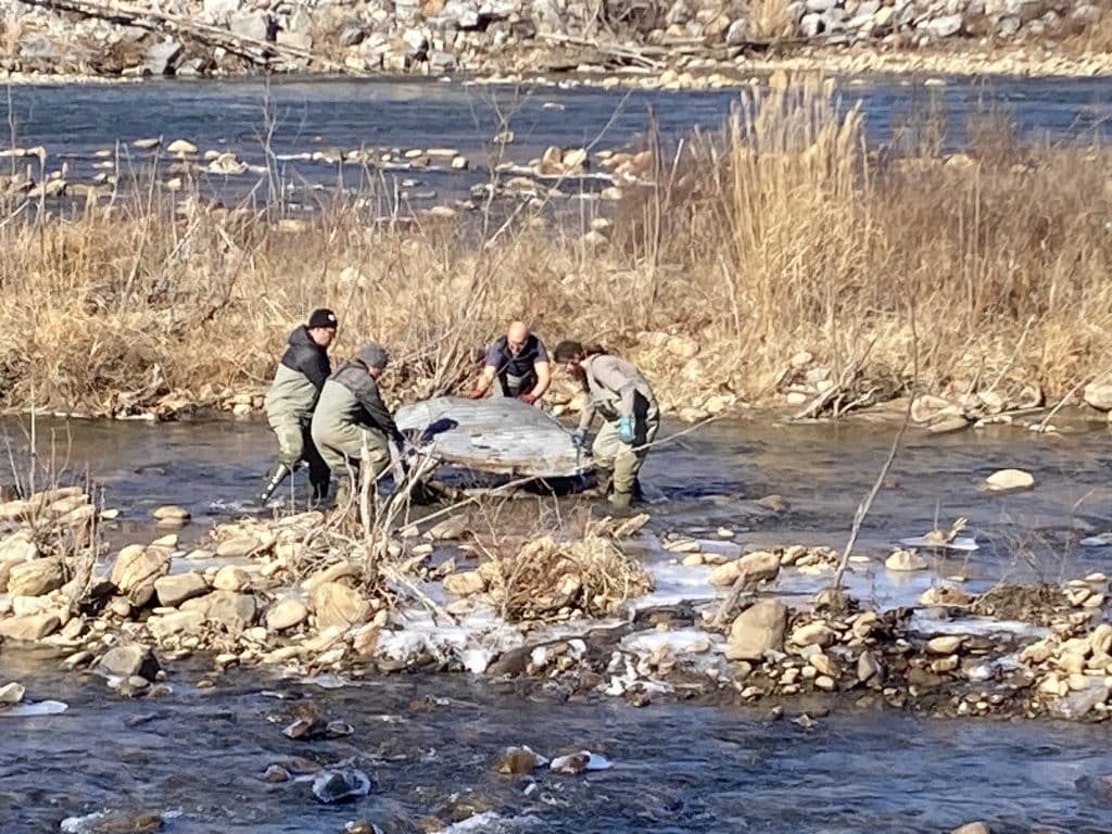 Volunteers from the Nolichucky Outdoor Recreation Association remove a large piece of metal left behind in the Nolichucky River by debris removal contractors. Photo by Peggy Cantrell