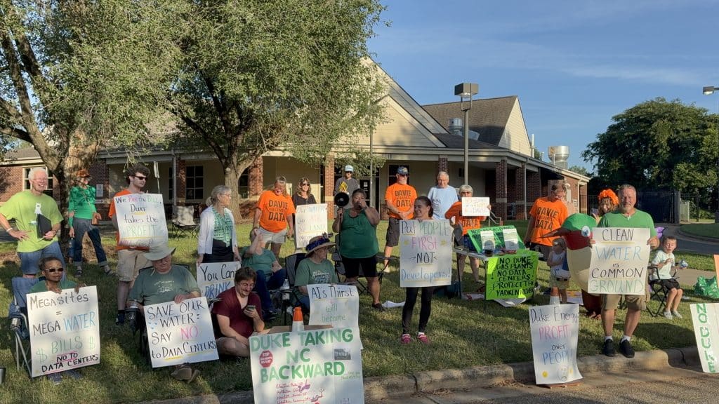 Protesters hold up signs objecting to Duke Energy proposal
