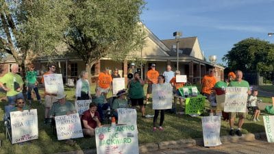 Protesters hold up signs objecting to Duke Energy proposal