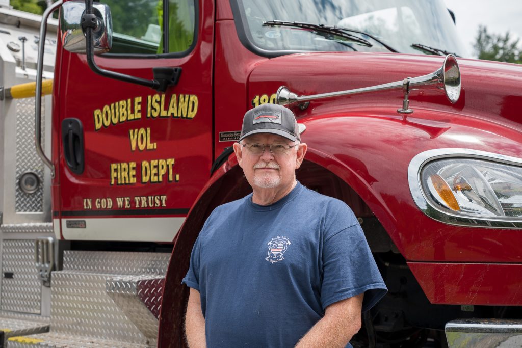 Dan Buchanan stands in front of Double Island Volunteer Fire Department's fire engine
