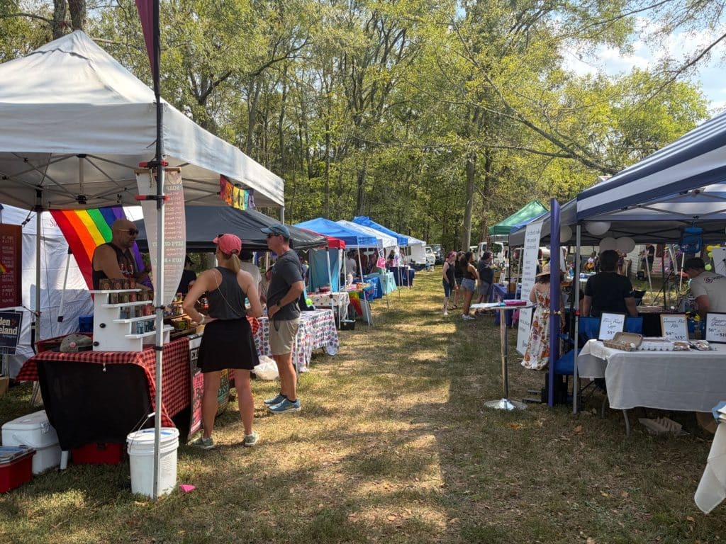 Rows of vendors under pop-up tents are filling a grassy area at the annual Affirming Sumner Pride celebration in Middle Tennessee. Pride flags are hanging on some booths