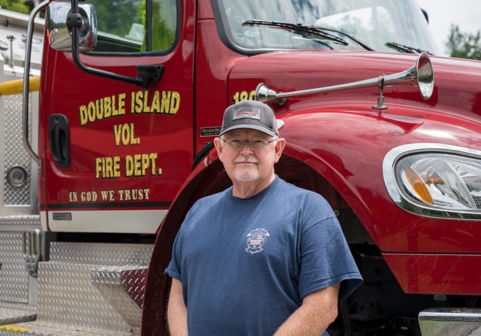 Dan Buchanan stands in front of Double Island Volunteer Fire Department's fire engine