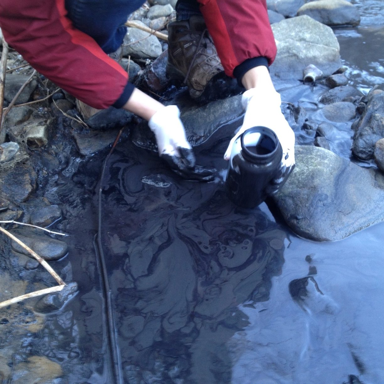 Erin Savage gathers samples at the site of the Fields Creek slurry spill in February 2014