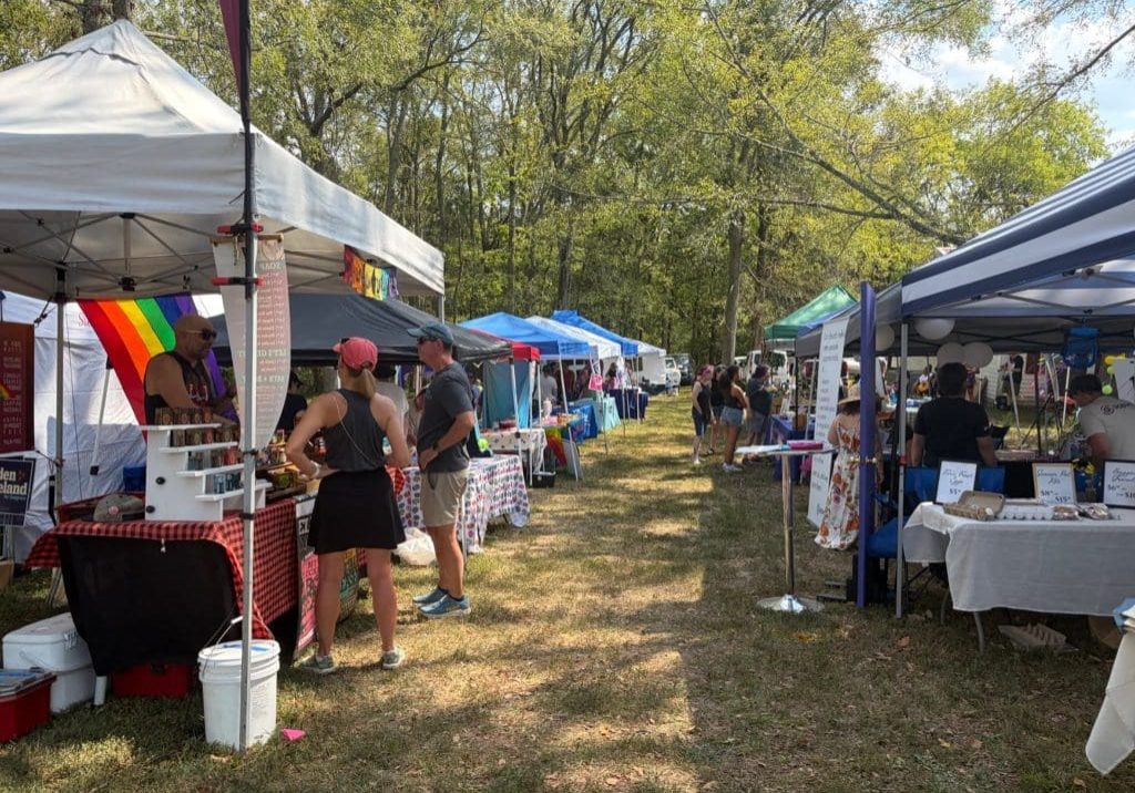 Rows of vendors under pop-up tents are filling a grassy area at the annual Affirming Sumner Pride celebration in Middle Tennessee. Pride flags are hanging on some booths